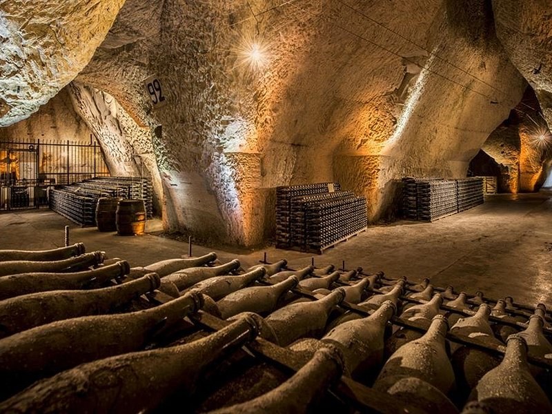 Bottles ageing in rows on the floor of a high chalk pit cut by hand