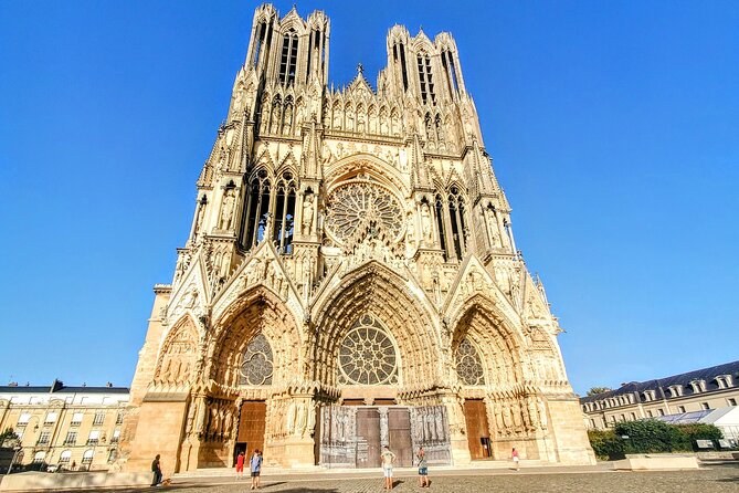 The carved portals and rose window of Reims Cathedral's west front in full sun